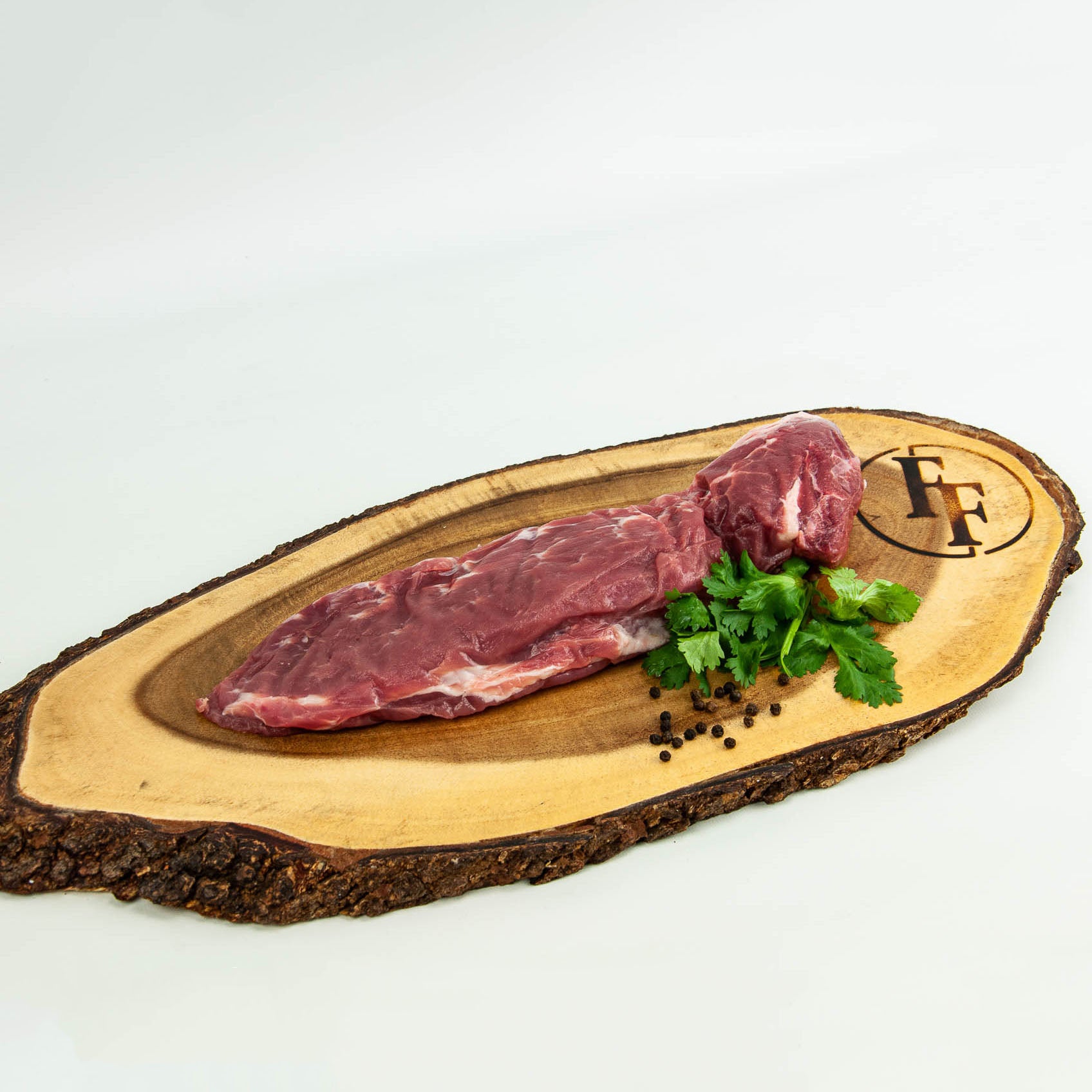 Two pieces of raw meat on a wooden board with herbs and pepper, branded 'FF'.