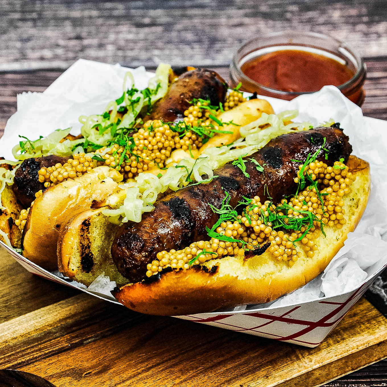 Hot dogs with mustard, onions, and relish on a wooden table