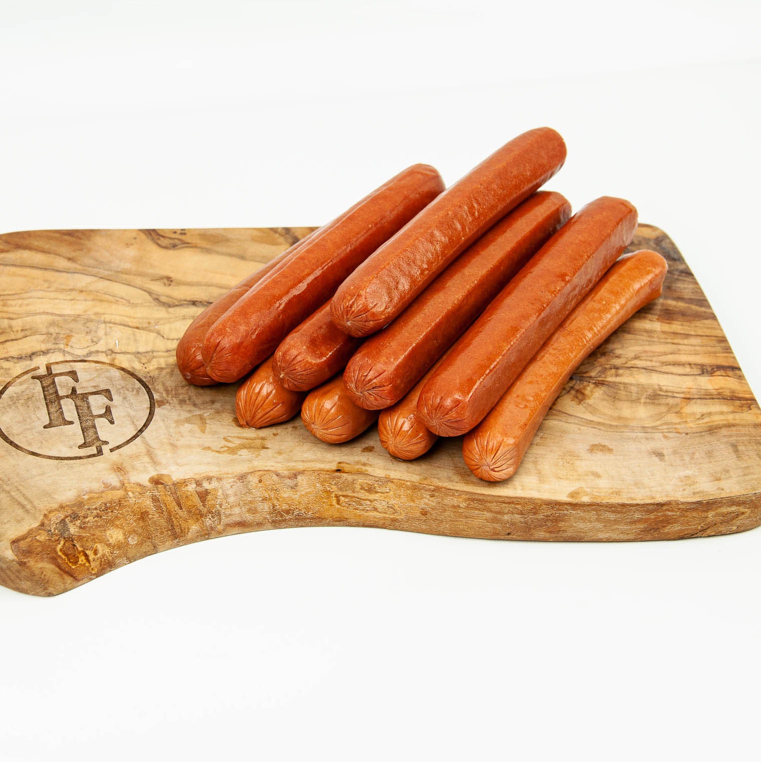 Hot dogs on a wooden cutting board with a brand logo.