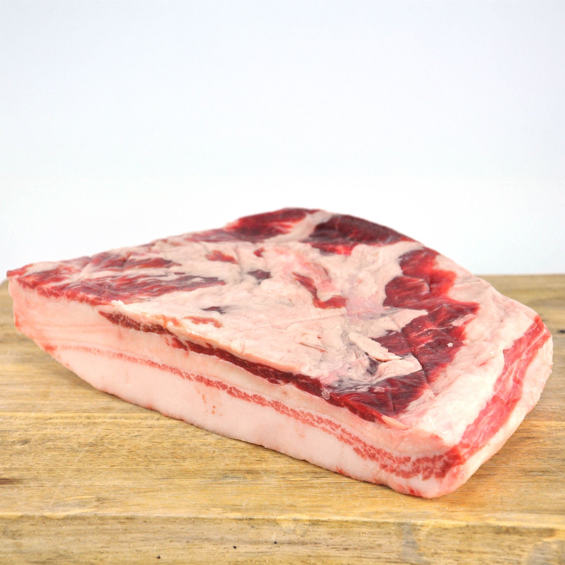 Raw meat block on a wooden surface with a white background