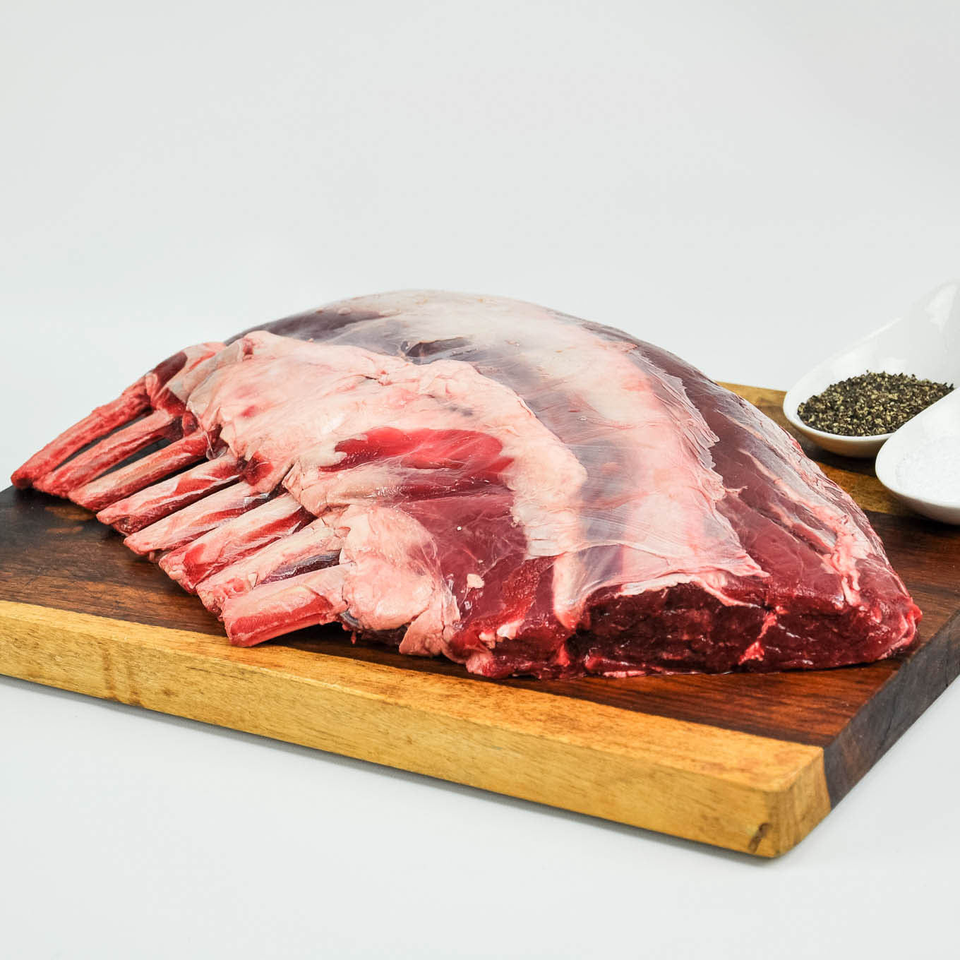 Raw meat on a wooden cutting board with a white background