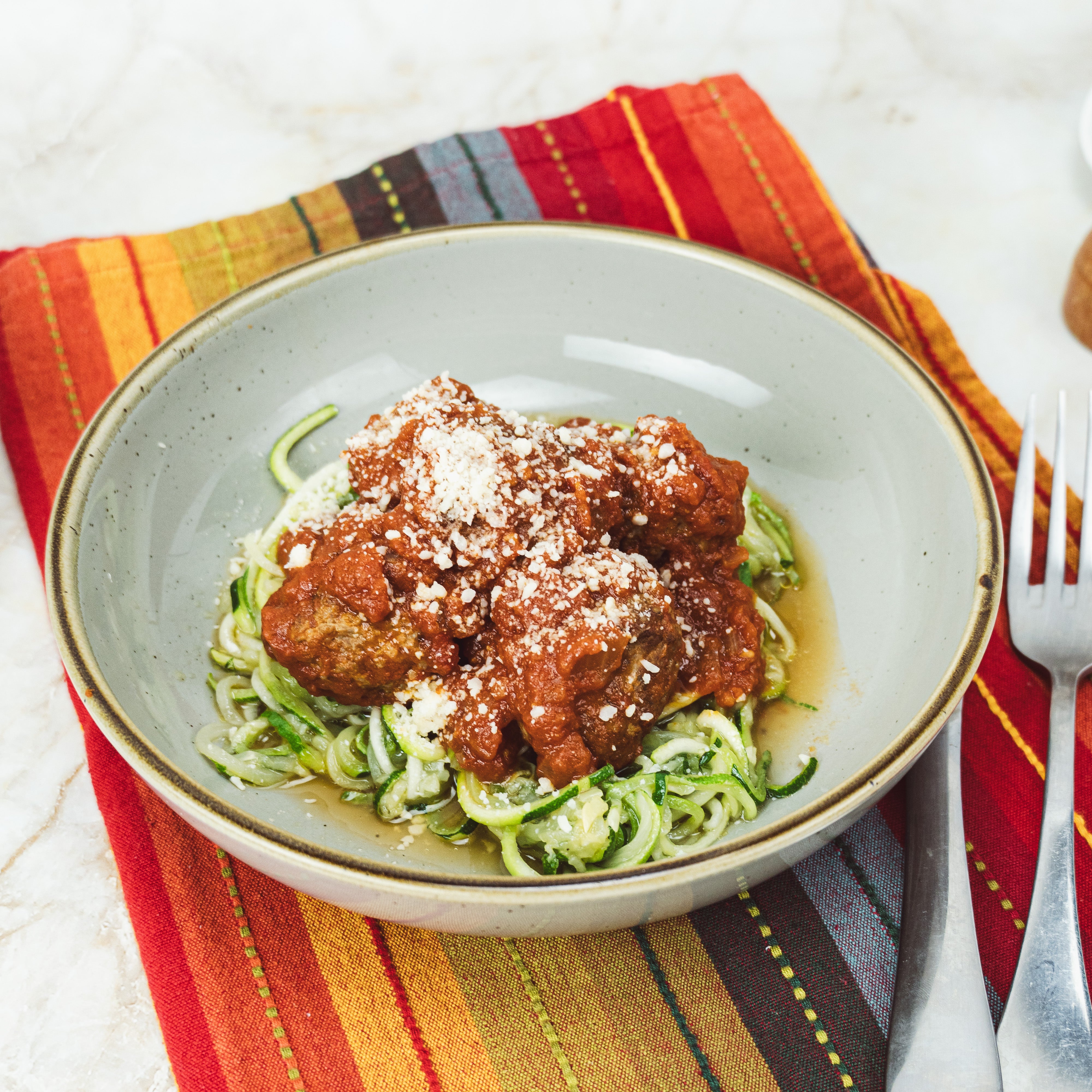 a bowl of zucchini noodles and meatballs