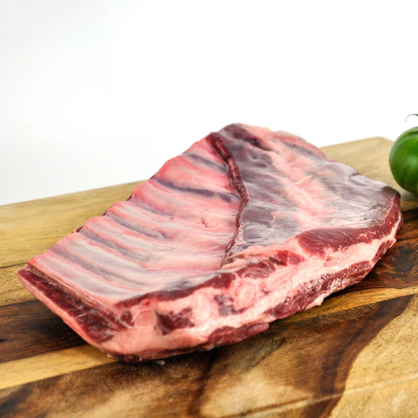 Raw meat on a wooden cutting board with a white background