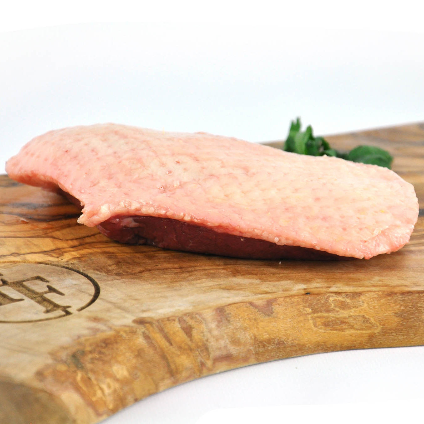 Raw meat on a wooden cutting board with a blurred background