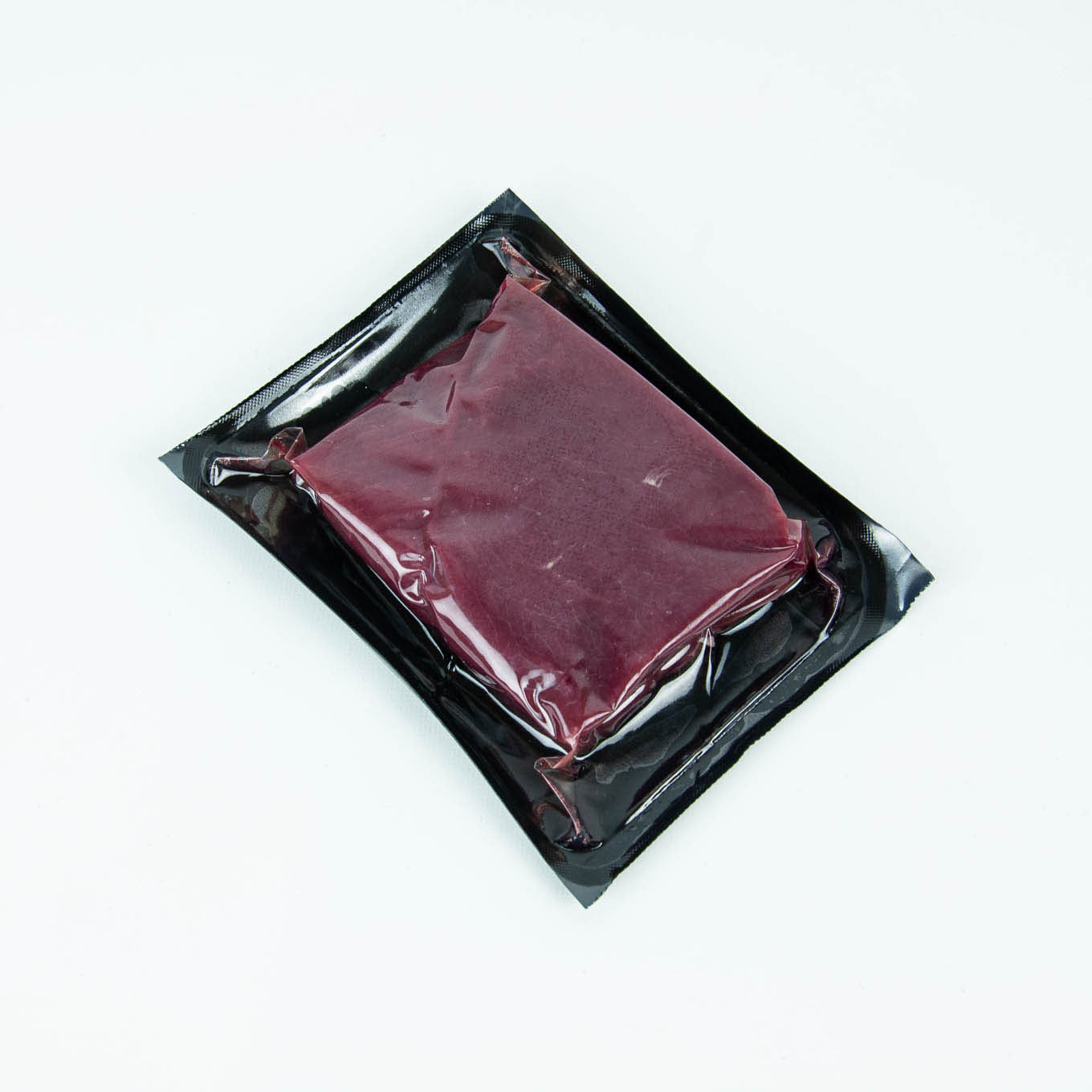 Vacuum-sealed package of raw meat on a white background
