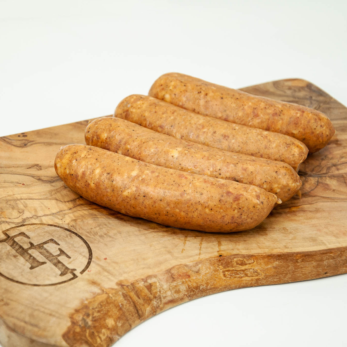 Raw sausages on a wooden cutting board with a brand logo.