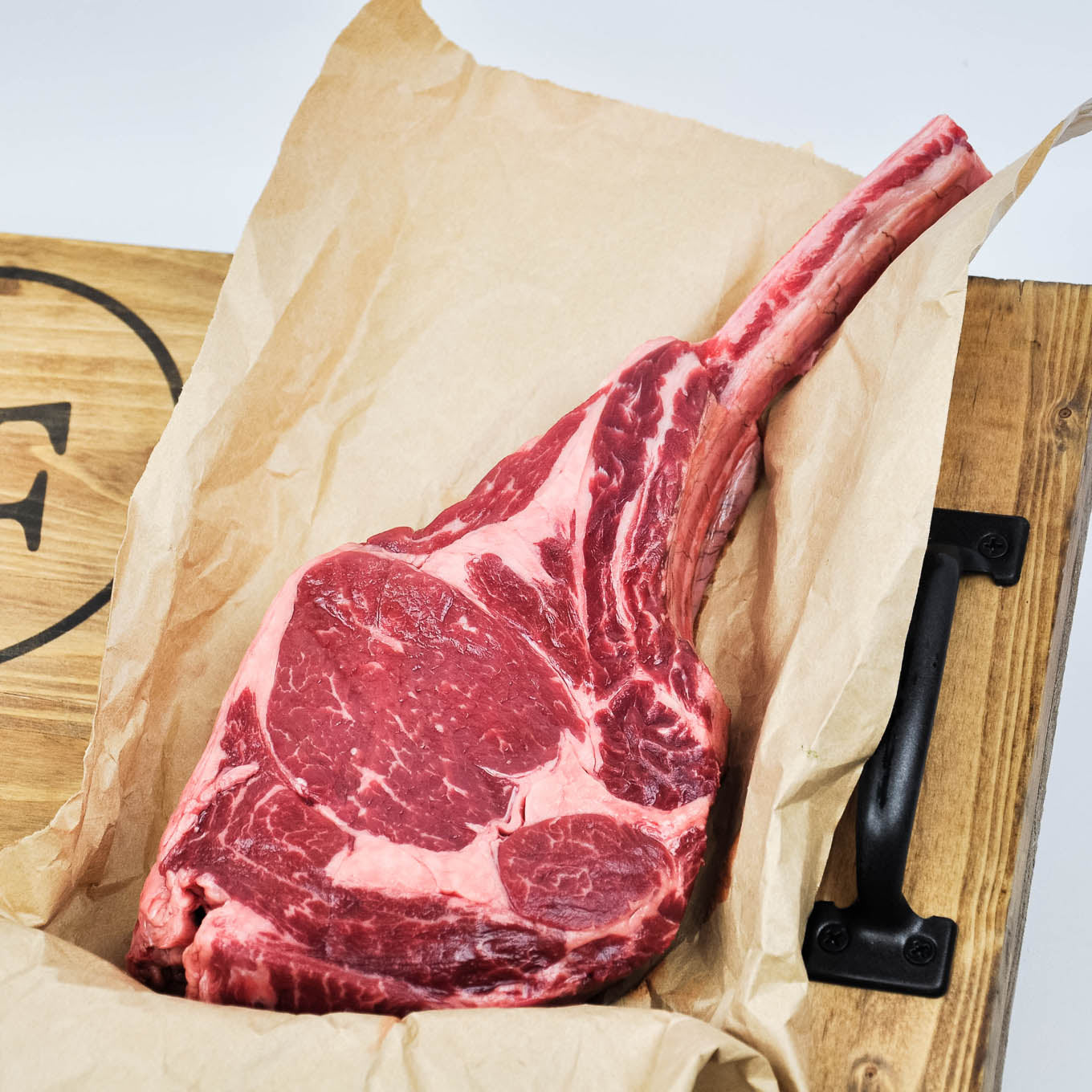 Raw steak on brown paper with a wooden background