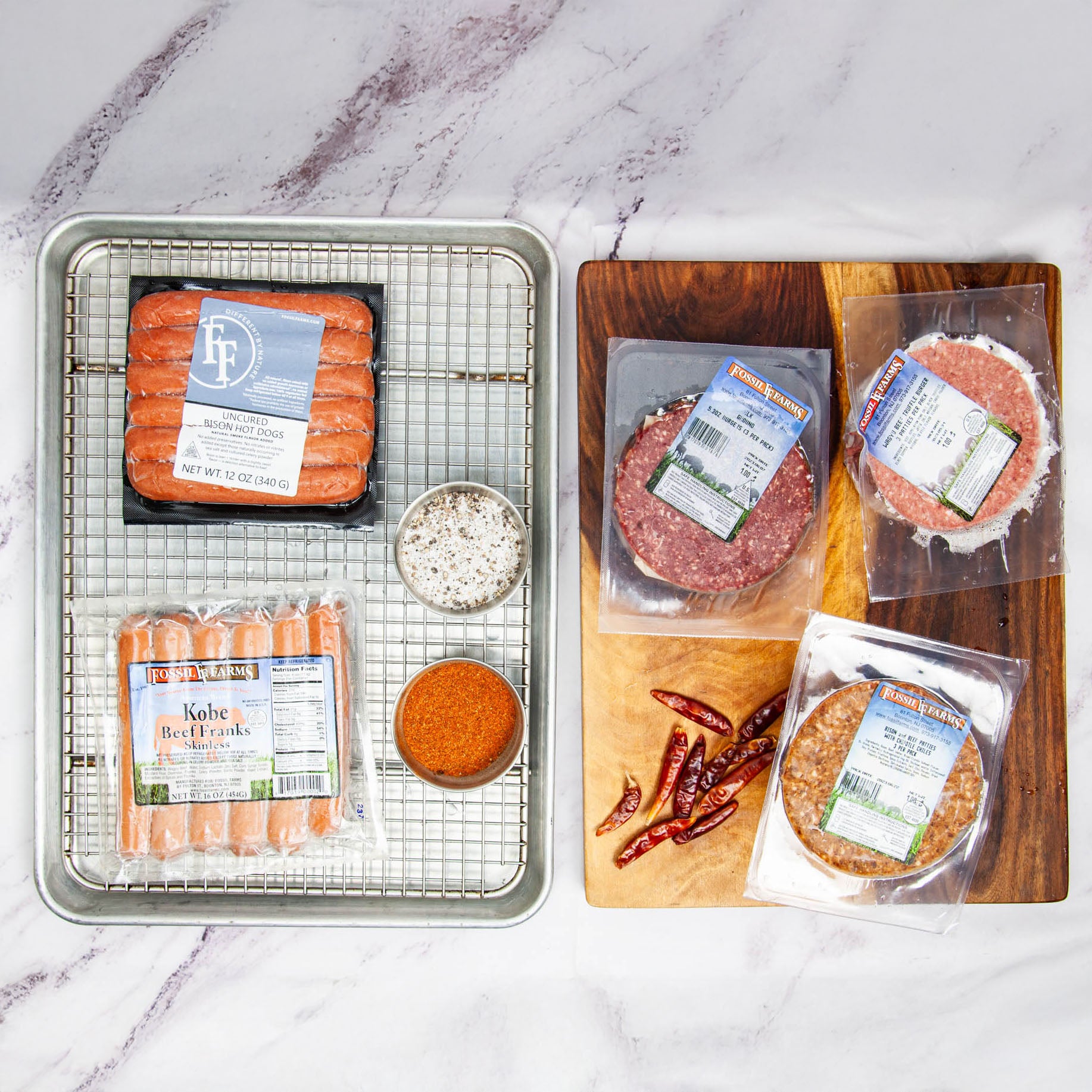 Assorted packaged meats and spices on a marble surface