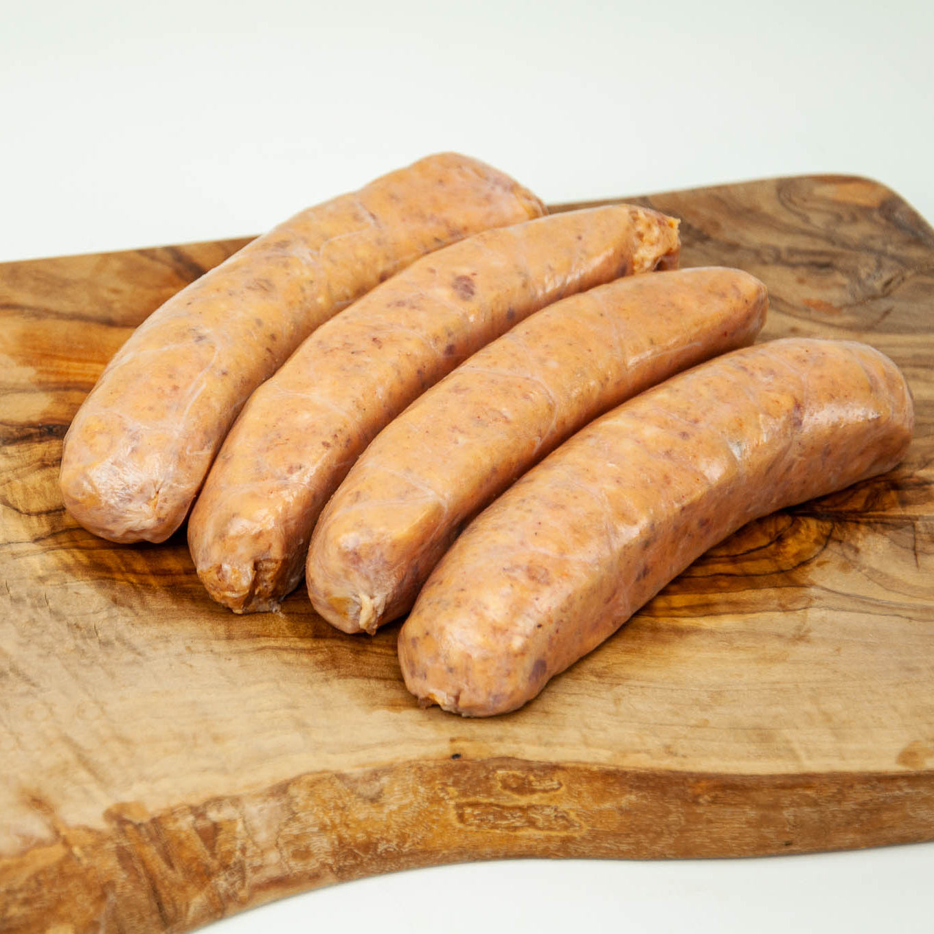 Raw sausages on a wooden cutting board