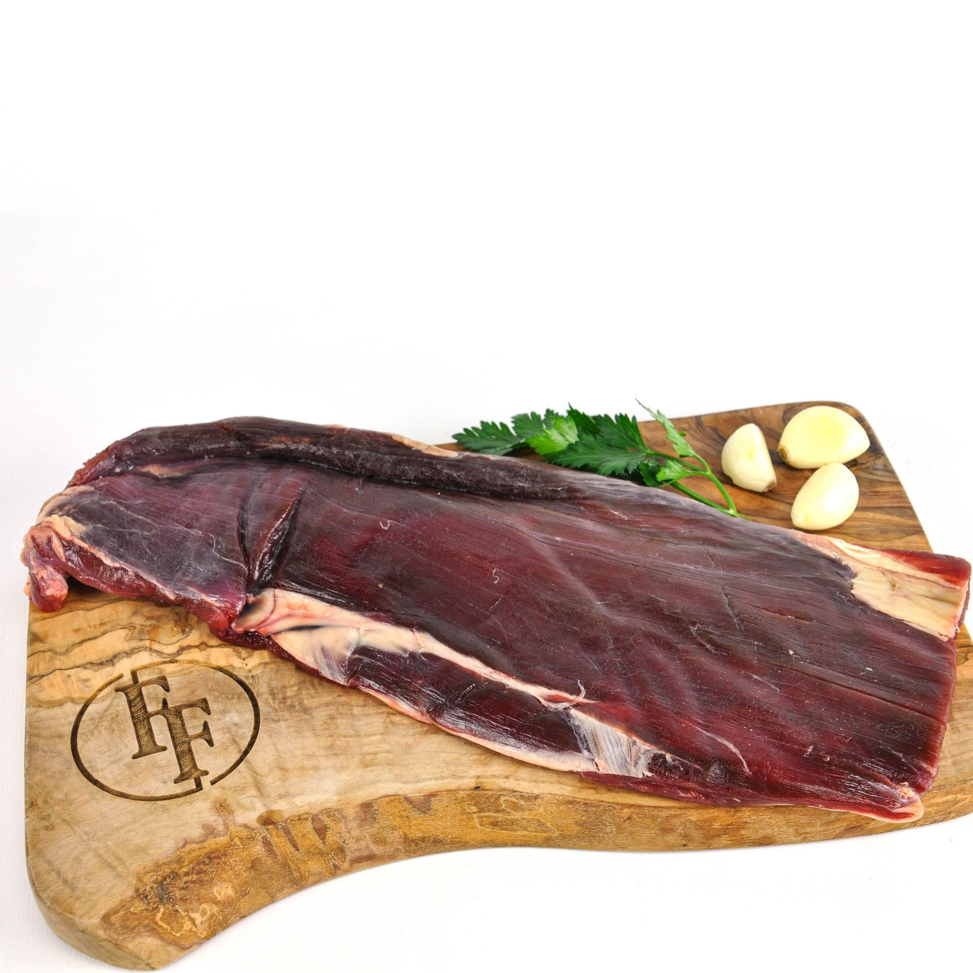 Raw fish on a wooden cutting board with herbs and garlic, branded 'HFF'.