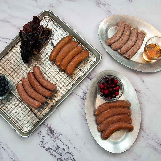 Assorted sausages on metal trays with a marble background