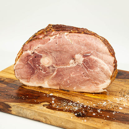 Sliced ham on a wooden cutting board with a white background