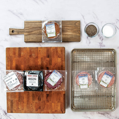 Assorted packaged meats on a marble surface with cutting boards and a tray.