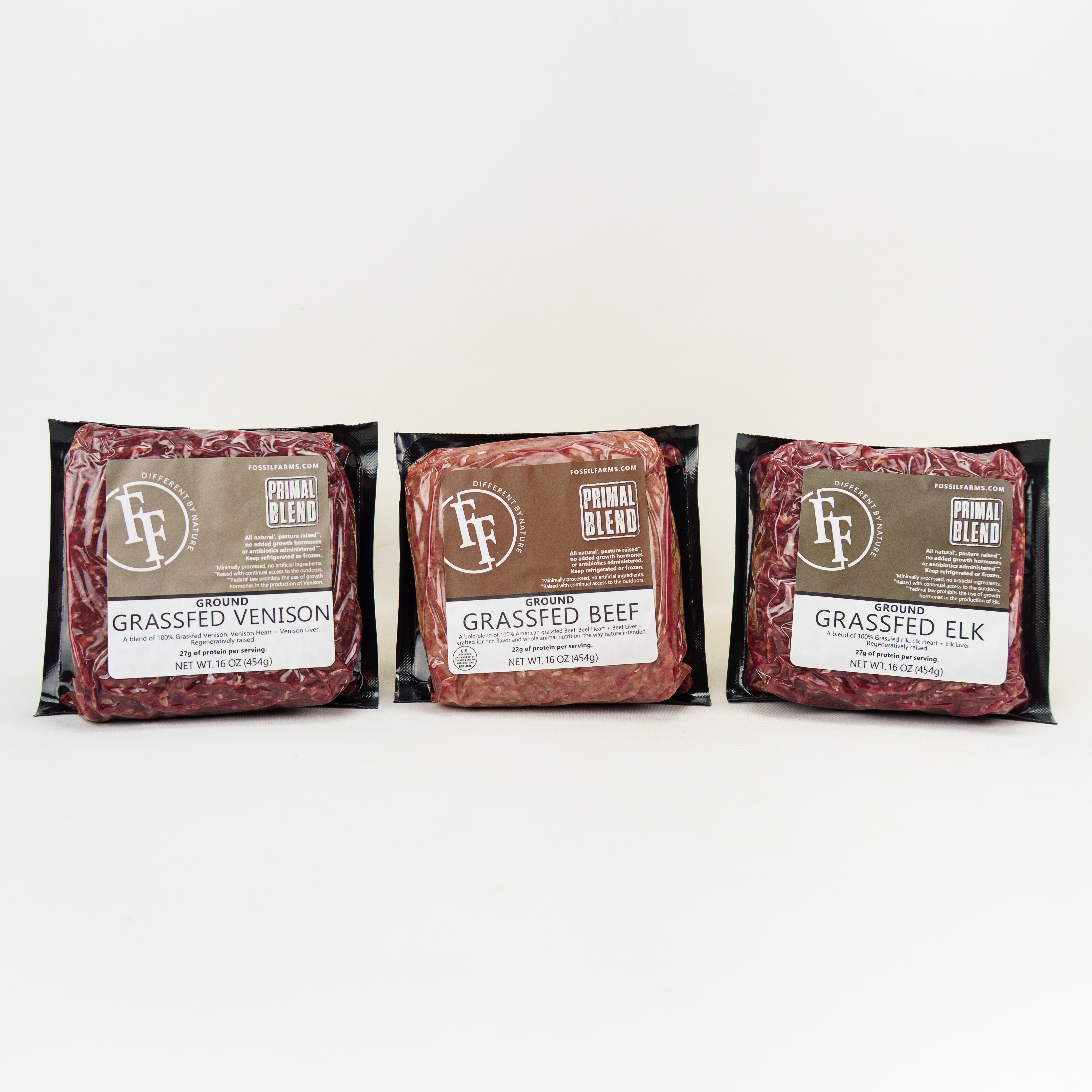 Three packages of grassfed venison, beef, and elk on a white background