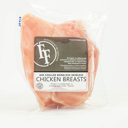 Packaged chicken breasts with a label on a white background