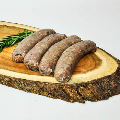 Raw sausages on a wooden cutting board with rosemary