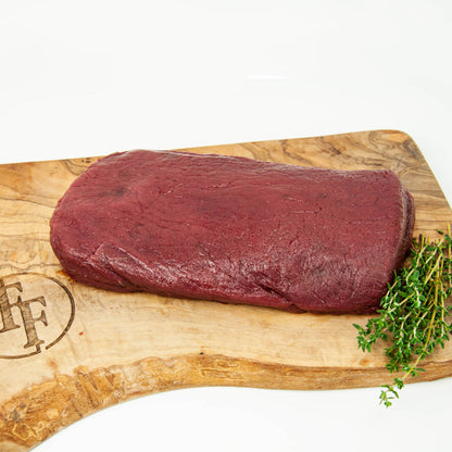 Raw meat on a wooden cutting board with a brand logo, on a white background