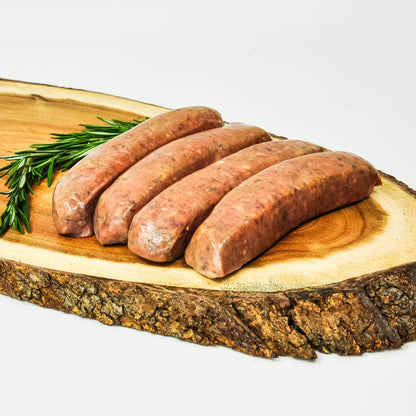 Raw sausages on a wooden cutting board with rosemary sprigs.