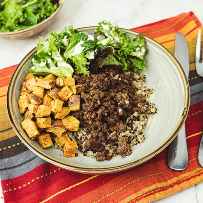 a bowl of quinoa with sweet potatoes, and ground meat 