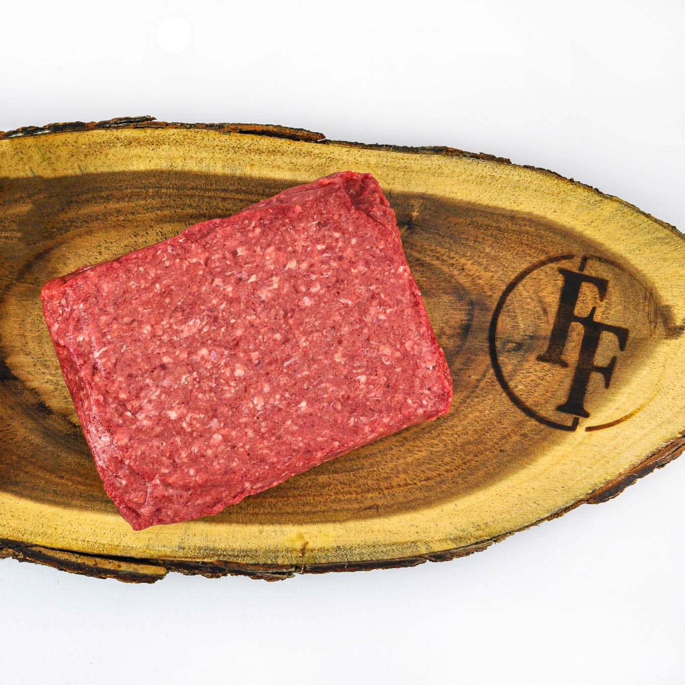 Block of raw ground meat on a wooden board with a brand logo.