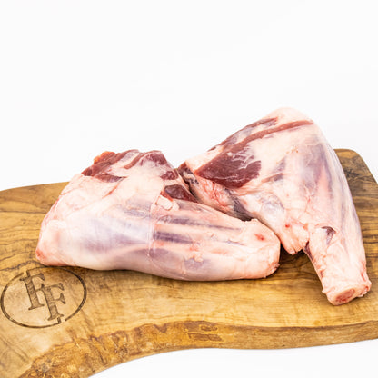 Raw meat on a wooden cutting board with a brand logo.