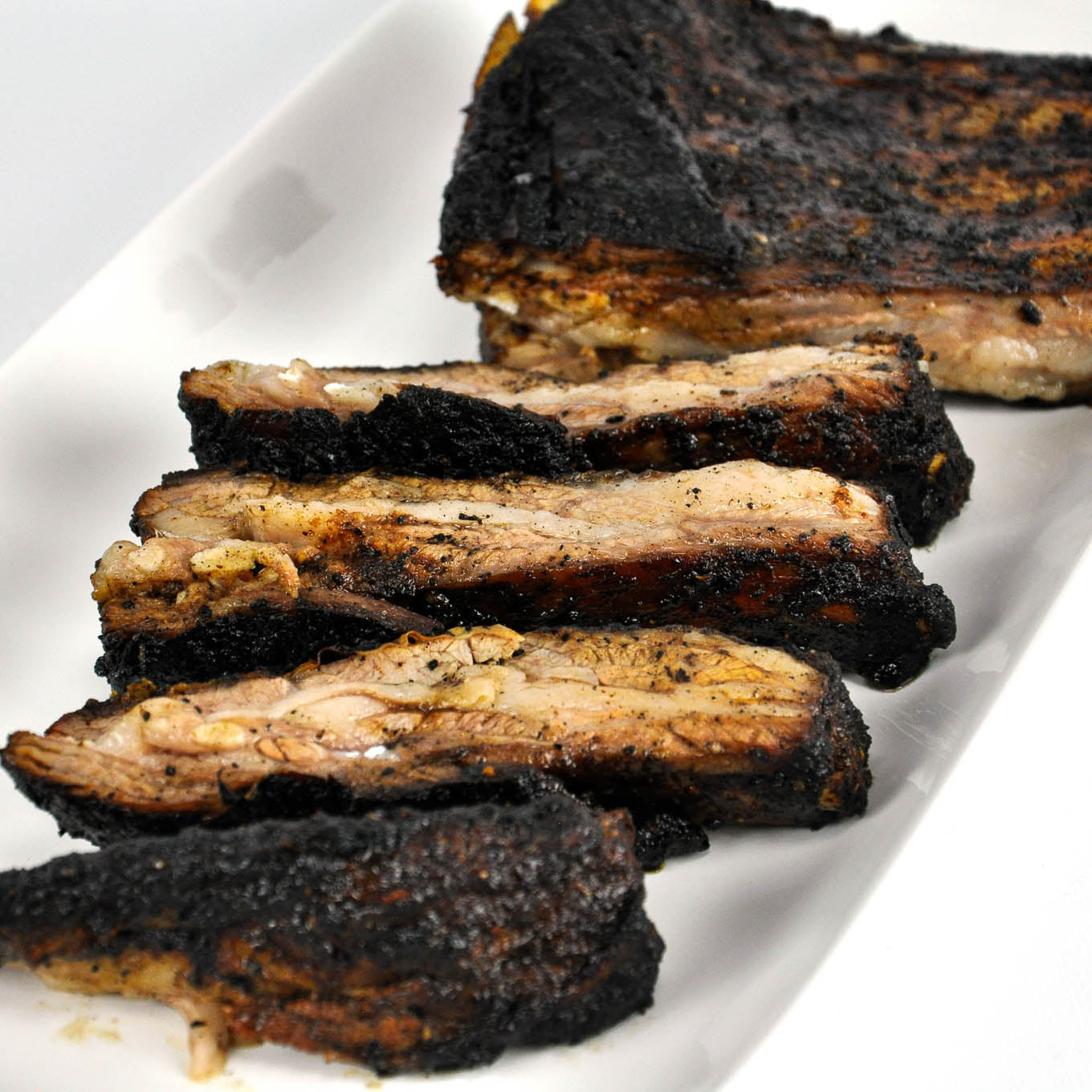 Grilled ribs on a white plate with a blurred background
