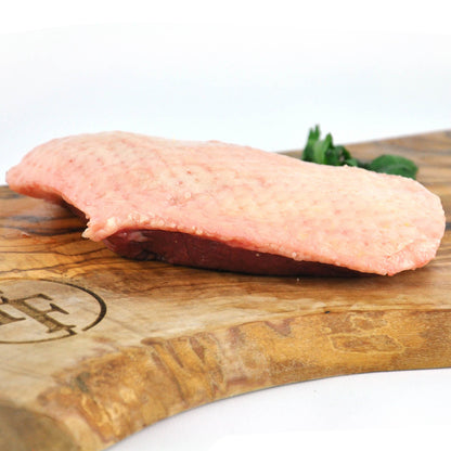 Raw meat on a wooden cutting board with a blurred background