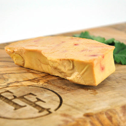 Block of cheese on a wooden board with a brand logo