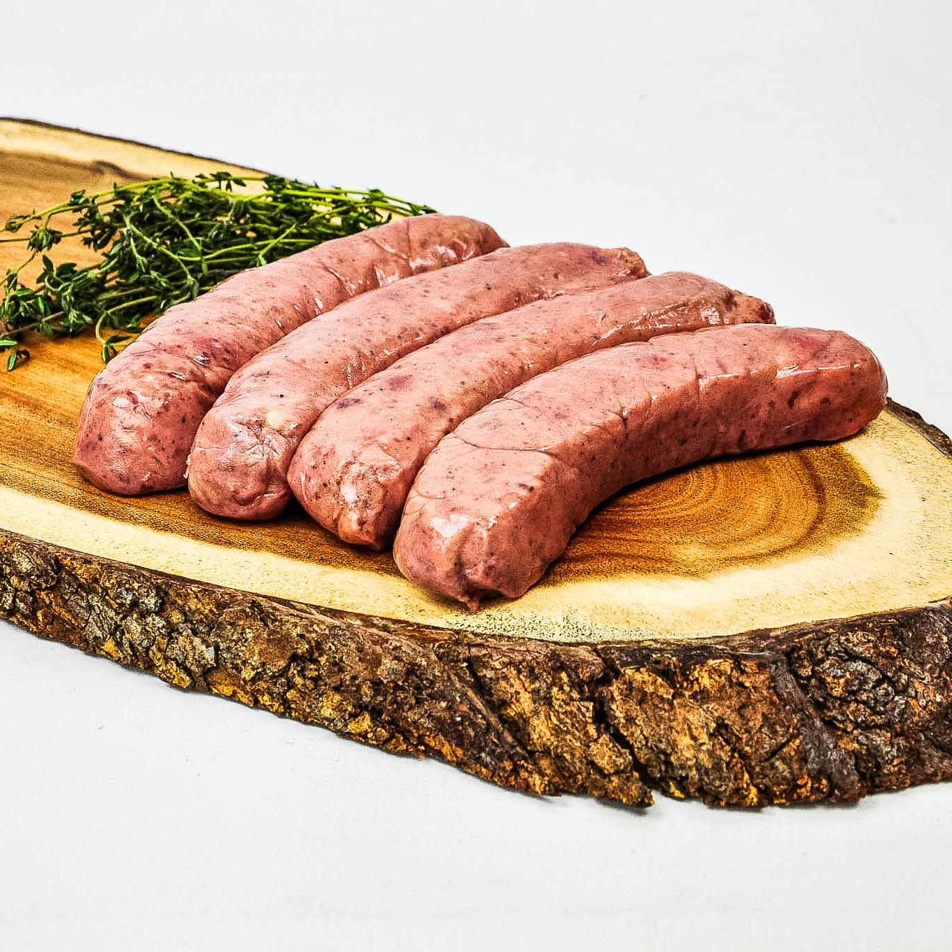 Raw sausages on a wooden cutting board with a white background
