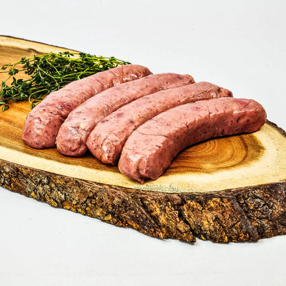 Raw sausages on a wooden cutting board with a white background