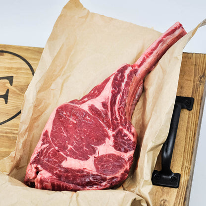 Raw steak on brown paper with a wooden background