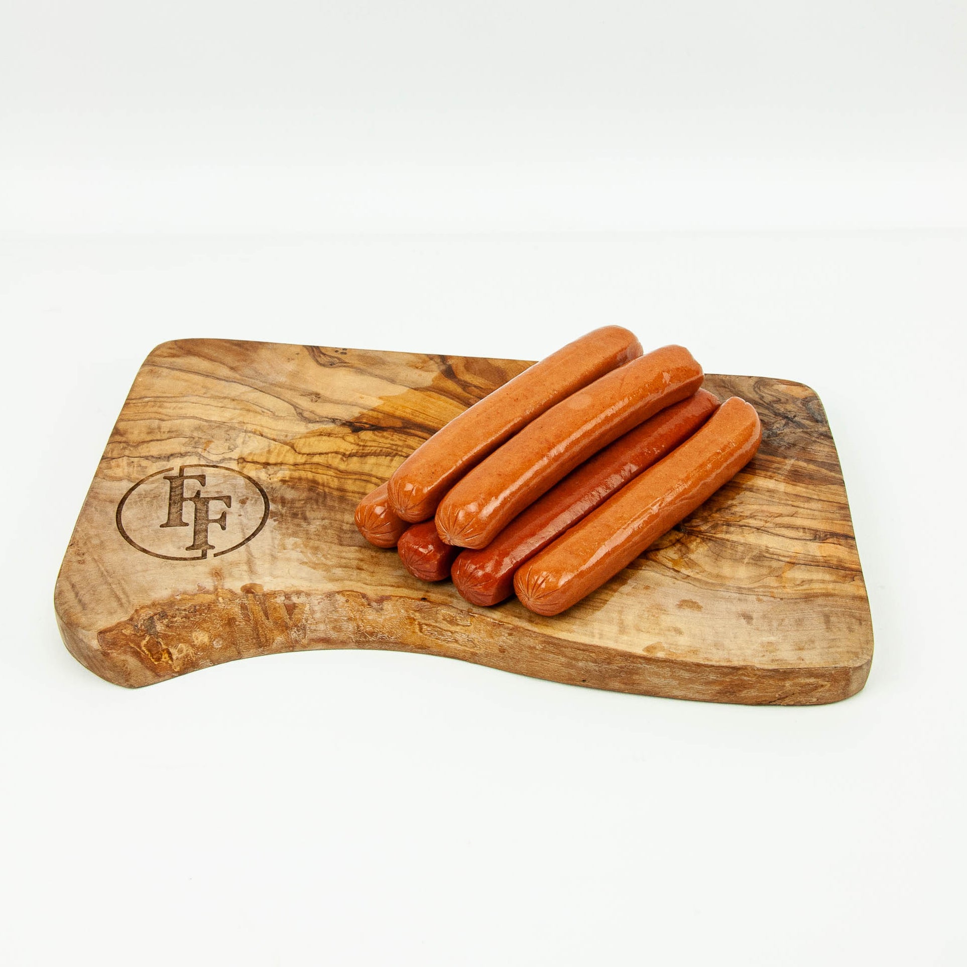 Wooden cutting board with hot dogs on a white background