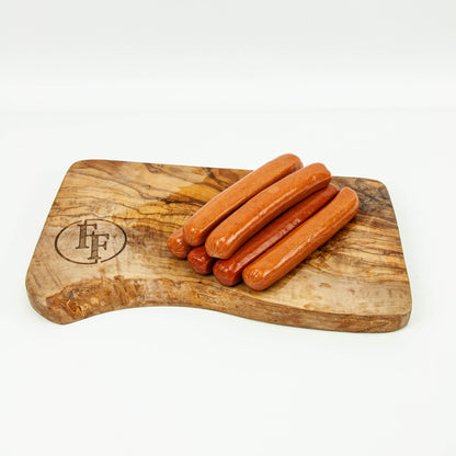 Wooden cutting board with hot dogs on a white background