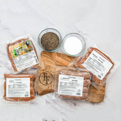 Packaged sausages on a wooden cutting board with salt and pepper bowls on a marble surface.