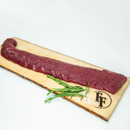 Raw meat on a wooden board with rosemary and a brand logo on a white background