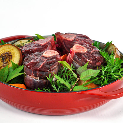 Red dish with raw meat and vegetables on a white background