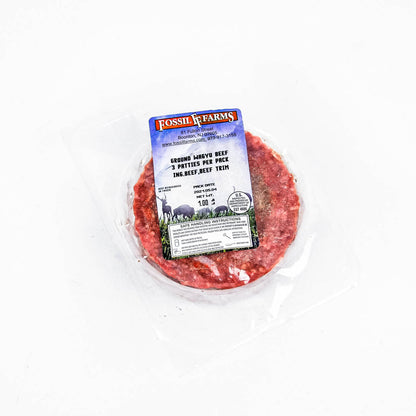 Ground beef patty in a packaging with a Fossil Farms label on a white background