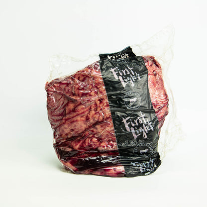 Packaged meat with a black label on a white background