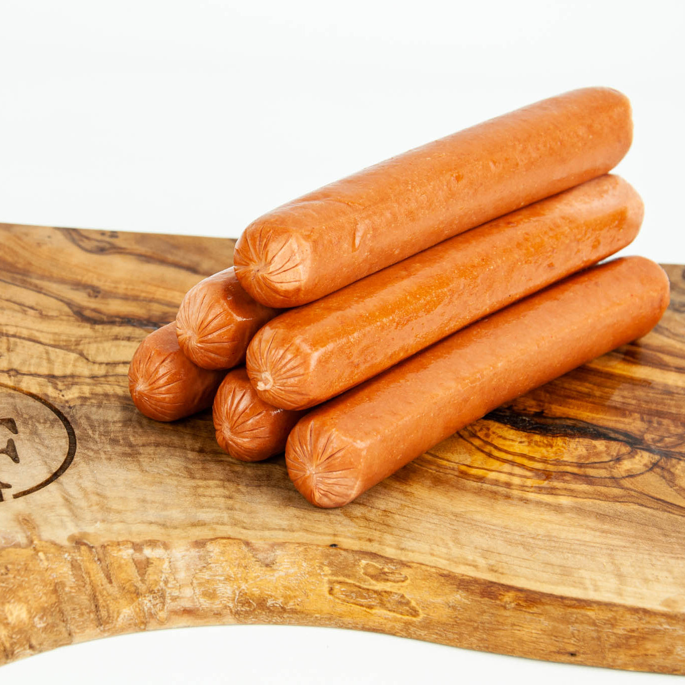 Stack of hot dogs on a wooden cutting board
