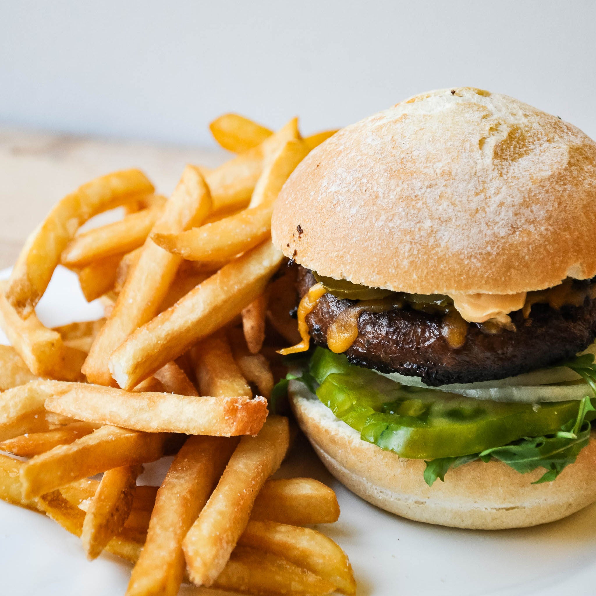 Hamburger with fries on a white plate